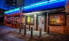 an old building with neon lights on the side of it's doors and windows