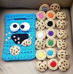 a crocheted blue bag with eyes and googly eyes next to other crocheted items