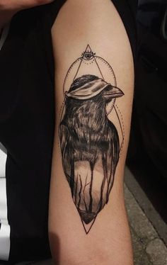 a black and white tattoo with a bird on it's arm, in the shape of a triangle