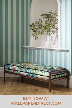 a bed sitting in the middle of a room next to a wall with striped walls