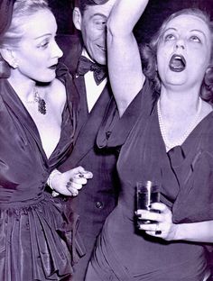 an old black and white photo of people at a party with drinks in their hands