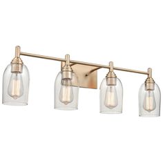 three light bathroom fixture with clear glass shades and gold metal fixtures on an aged brass finish