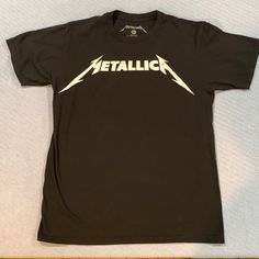 a black t - shirt with the word metallic on it and two white lightning bolts