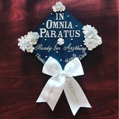 a blue graduation cap with white flowers on it that says in omnia paratus ready for anything