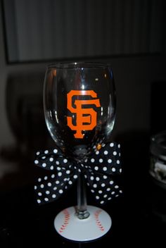 a wine glass with the san francisco giants on it and a polka dot bow tie