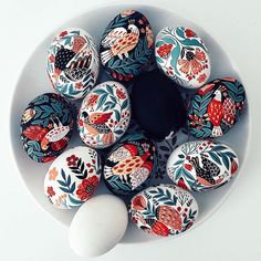 an arrangement of painted eggs in a bowl