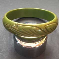 Lovely pea soup green Bakelite Bangle. Carved and over dyed. In great condition. I'm going to say this is a child's Bangle due to the size. Nice simple carving. Measurements are : Opening: 2 5/16 Thickness: 9/16 Shipping is an estimate only. Lots of other Bakelite in my shop. Martini Set, Bakelite Bracelets, Bakelite Bangles, Pea Soup, Cool Items, Peas, Olive Green, Bangle Bracelets, Jewelry Bracelets