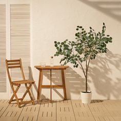 a chair and table with a potted plant next to it on a wooden floor