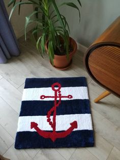 an anchor rug is on the floor next to a potted plant