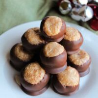 a white plate topped with lots of chocolate covered candy eggs and cookies on top of each other