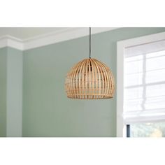 a bamboo light fixture hanging from a ceiling in a room with green walls and windows