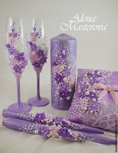 purple wedding decor with flowers and pearls on the table next to two wine glasses, napkins and candle holder