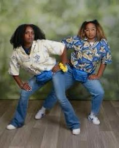 two young women posing for a photo in front of a green wall and wood floor