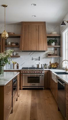 a kitchen with wooden cabinets and stainless steel appliances, including an oven, sink, dishwasher, and stovetop