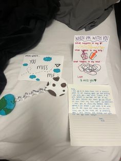 a bed topped with lots of writing and paper on top of it next to a note