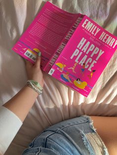 a person laying in bed with a book on top of their head, reading happy place