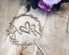 a bouquet of flowers sitting on top of a wooden table next to a laser cut heart