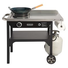 an outdoor grill with a pot on the burner and a propaner attached to it