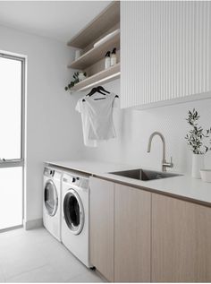 a washer and dryer sitting in a kitchen next to an open sink window