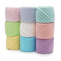 six balls of yarn in pastel colors are stacked on top of eachother