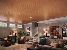 a living room with couches, chairs and stairs leading up to the second floor