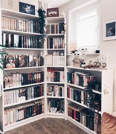 a white bookcase filled with lots of books on top of a hard wood floor