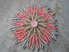 an intricately designed piece of paper is shown on the ground, with pink and white accents