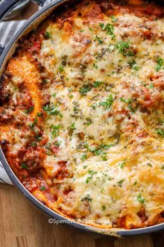 a casserole dish with meat and cheese in a pan on a wooden table