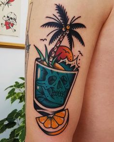 a man's arm with a skull in a cup and palm tree on it