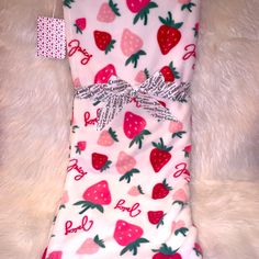 a white blanket with strawberrys on it and the words love is written in red