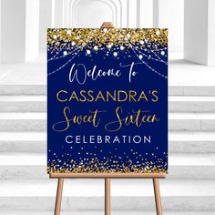 a blue and gold welcome sign sitting on top of a wooden easel in front of some steps