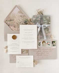 the wedding stationery is laid out on top of each other, including an envelope with a ribbon