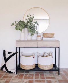 an instagram photo with baskets and plants on the sideboard next to a mirror