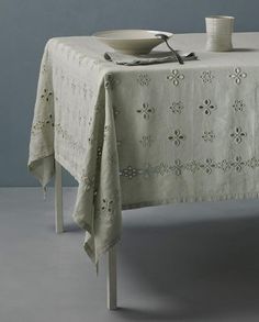 a table with a white cloth on it and two plates sitting on top of it