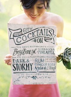 a woman holding up a sign that says get to cocktails on