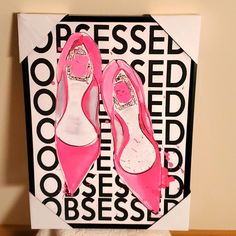 a pair of pink high heeled shoes sitting on top of a white box next to a black and white wall