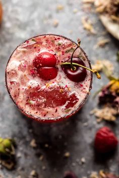 a drink with cherries in it on a table