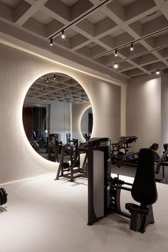 an exercise room with mirrors and treadmills in the center, all lit up by lights