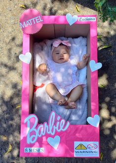 a baby is laying in a pink box with hearts on it's head and name barbie