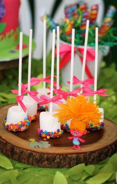 cake pops are arranged on a wood slice