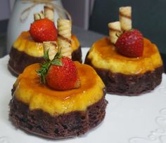 two desserts with strawberries on top are sitting on a plate