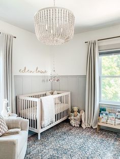 a baby's room with a chandelier hanging from the ceiling and furniture