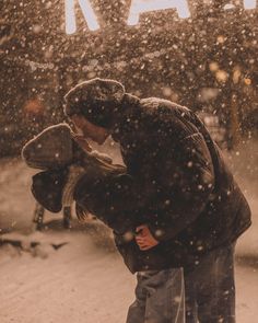 a man and woman kissing in the snow