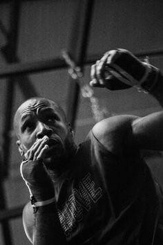 a black and white photo of a man holding his hands to his mouth