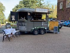 a food truck parked on the side of a road with tables and chairs around it