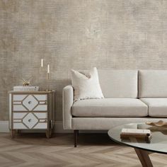 a white couch sitting next to a table on top of a hard wood floored floor