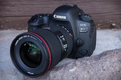 a canon camera sitting on top of a rock