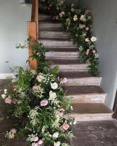 some flowers are growing up the side of stairs