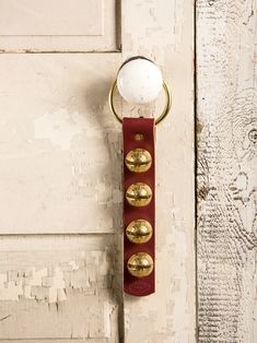 a door handle with three brass knobs and a white ball on the top one