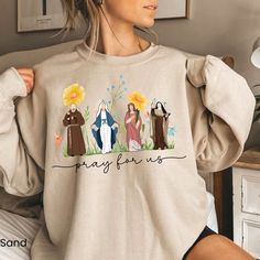 Looking for Catholic Saints Sweatshirt for women Catholic Gifts Catholic Sweatshirt Marian Cross Floral Women Religious Shirts Religious sweatshirt ? You're in the right Place.  This Floral Saint  Sweatshirt Makes a perfect Gift For Her . SIZING GUIDELINES Our sweatshirts are true to size, for an oversized look , we recommend 2 sizes up. HOW TO ORDER OUR  SWEATSHIRTS, 1 ) Please, check and review all photos for size & Shirt details Catholic Shirts, Catholic Clothing, Catholic Shirt, Saints Shirts, All Saints Day, Sweatshirt For Women, Jesus Art, Pretty Clothes, Catholic Gifts